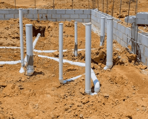 uPVC waste and soil stub-ups standing in a foundation before the floor slab